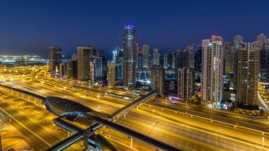 Dubai Yat Limanı gökdelenler hava üstten görünüm güneş doğmadan önce Jlt gelen Dubai gece gün timelapse, Birleşik Arap Emirlikleri için. Işıklı modern kuleleri ve Şeyh zayed yolu üzerinde trafik.