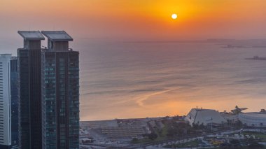 The skyline of West Bay and Doha City Center during sunrise timelapse, Qatar. Modern skyscrapers. Gulf on background clipart