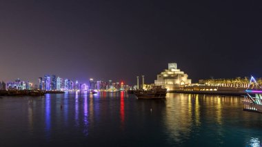 Katar 'ın Doha kentindeki eski dhow liman gecesi hiperhızının panoramik bir görüntüsü. Arka planda West Bay silueti var. Arka planda modern gökdelenler ve müzeler ve ön planda eski tekneler