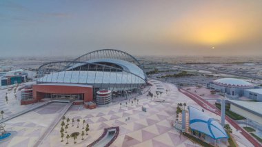 Doha 'da güneş doğarken Aspire Bölgesi' nin havadan görüntüsü. Yollarda ve araba parklarında trafik vardı. Sisli hava