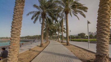 Katar 'ın başkenti Doha' da bulunan yedi kilometre uzunluğundaki Corniche 'nin bir ucunda bulunan MIA Park zaman atlamasında yürü. Avuçlar yolun her iki tarafında.