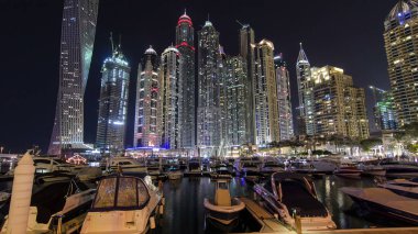 Dubai Marina 'nın en yüksek gökdelenleri, konut kuleleri ve tekneleriyle liman gecesi Dubai, Birleşik Arap Emirlikleri' nde hiper hız.