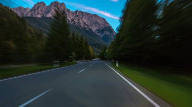 Avusturya, bir güzel sonbahar günü timelapse hyperlapse drivelapse Alpler'de asfalt yolda sürücü. Orman ve dağlar akşam