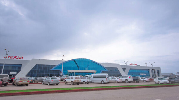 Gateway to the Skies: Aktobe City Airport Timelapse Hyperlapse. Clouds Drift Overhead as Parking Bustles at the Entrance, Showcasing the Urban Connectivity of Western Kazakhstan