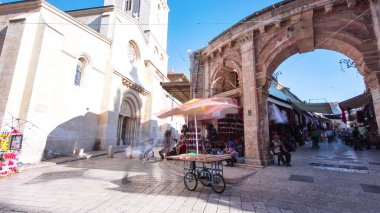 Eski Kudüs şehrinde, kilisenin yanındaki renkli çarşıda İsrail zaman atlaması yaşıyor. İnsanlar bu Makret 'le geçiyor.