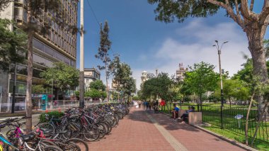 Jose Larco Bulvarı 'nda kırmızı bisiklet pisti ve Miraflores, Lima Peru' da bisiklet parkında hız sınırı. Central Park sağda ve caddede trafik var.
