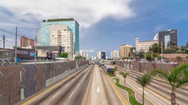 Via Expresa otoyolu ve trafikle dolu metropolitan otobüsün hava manzarası ve bulutlu mavi gökyüzü. Arka planda gökdelenler. Lima, Peru