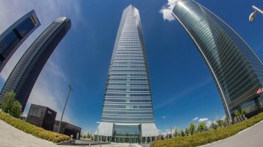 Madrid ve İspanya 'nın en yüksek gökdelenlerinin bulunduğu Dört Kuleler İş Alanında gökdelenler zaman atlaması yaşıyor. Bulutlu mavi gökyüzü. balık gözü