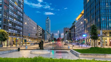 Evening in business part of city Milan located on the Vittor Pisani Street (Via Vittor Pisani) day to night timelapse. Traffic on the road. Light in windows clipart