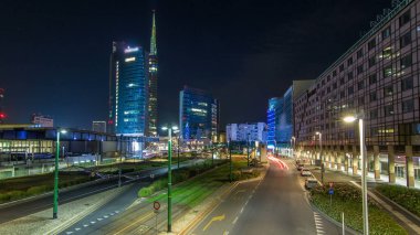 Milan Porta Nuova iş ilçe gece timelapse, Milano, İtalya içinde modern gökdelenler ile manzarası. Yolda trafik. Işık içinde pencere eşiği. Köprüsü'nden Üstten Görünüm