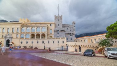 Prince 's Palace of Monaco zaman atlaması ve önünde kare şeklinde. Burası Monako Prensi 'nin resmi konutu. Yaz günü bulutlu bir gökyüzü. Etrafta dolaşan insanlar