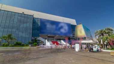 Red carpet stairway at Palais des Festivals et des Congres timelapse hyperlapse in Cannes, France. Sunny summer day. Tourists making a pictures clipart