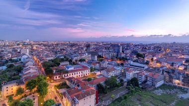 Porto 'nun eski kasabasının çatılarında panoramik hava manzarası sıcak bir bahar akşamında günden geceye geçiş, Porto, Portekiz. Işıklar yanıyor.