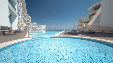 Güneşli yansımaları ve mavi su timelapse ile Otel küçük yüzme havuzu, Sesimbra, Portekiz plajında görünümü