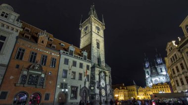 Prag 'daki Old Town Hall zaman atlaması (15. yüzyıl), şehir meydanı ve Leydi Tyn' ın peri masalı kilisesinin gece aydınlanması. Astronomik saat görünür.