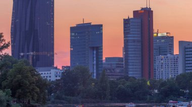 Vienna international center skyscrapers with Kaiserwasser lake reflection view day to night transition timelapse, Donaucity in capital of Austria. Colorful sky with clouds. Boats floating on a water clipart