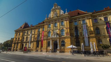 Museum of Arts and Crafts timelapse hyperlapse and a common blue tram in Zagreb during the day. Traffic on the road. Croatia