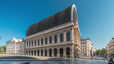 Modern cam kubbe ile birleştirilmiş neoklasik mimari içeren Lyons opera binasının hiperlapesi. Mavi gökyüzünün altında heykelleri olan tarihi ve turistik bir yer. Yan görünüm zaman dilimi