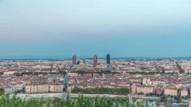 Gün batımından sonra Lyon 'un panoramik hava görüntüsü Fourviere Hill' den gece dönüşümüne kadar. Ufuk çizgisinde Rhone Nehri ve sıcak bir akşamda aydınlanan ikonik kent simgeleri yer alıyor.