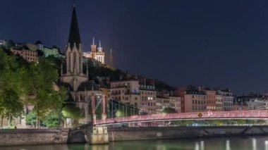 Aziz George Kilisesi, Quais de Saone ve Fourviere Bazilikası 'nın Fransa' nın Vieux Lyon kentindeki bir yaya köprüsünden hızlandırılmış zaman aşımına uğraması, geceleri tarihi mimari, yansımalar ve manzaralı nehir manzarası sergilenmektedir.