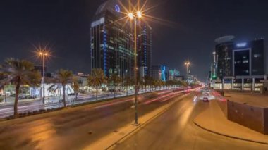Suudi Arabistan, Riyad 'ın şehir manzarası gece zaman çizelgesi. Işıklı kulelerin, gökdelenlerin, King Fahd Yolu 'nun ve yoğun trafiğin panoramik görüntüsü. Palmiyeler ve sokak lambaları şehrin içinden geçen ana otoyolda.