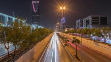 Riyad karayolu tüneli trafiğinin yer aldığı panoramik gece zaman çizelgesi, Krallık Kulesi Suudi Arabistan 'ın başkentinin en yüksek gökdeleni ve simgesi. Aydınlatılmış modern binalar çevre sahnesi