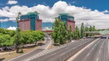 Centro Colombo 'nun ve Lizbon' daki modern ofis binalarının uçuş hızları. Otoyolda trafik vardı ve bulutlar mavi gökyüzünde hareket ediyordu. Şehir merkezindeki ünlü alışveriş merkezi. Portekiz