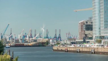 Hamburg kargo limanının zaman çizelgesi Elbe Nehri 'nde konteyner terminalleri, vinçler ve kargo gemileri sergileniyor. Tekneler ve gemiler modern binaların yanından geçerek dinamik bir deniz manzarası yaratıyorlar. Almanya
