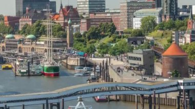 Jan Fedder Gezinti Alanı Hamburg, Almanya 'da canlı bir liman bölgesi. Gemiler ve tekneler Elbe Nehri 'nde ve arkasında ünlü binalar var. Rahatlama ve manzaralı güzellik