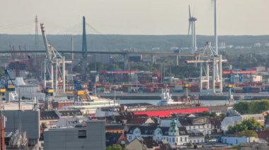 Hamburg kargo limanının hava zaman çizelgesi Elbe Nehri 'ndeki konteyner terminalleri, vinçler ve kargo gemileri. Rüzgar santrallerinde çalışıyorum. Tekneler ve gemiler geçiyor, deniz manzarası. Almanya