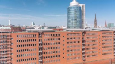 Modern Hamburg, Almanya 'nın hava zaman çizelgesi, konut ve ofis binalarının kırmızı tuğla cephelerini gösteriyor. Çok katlı evler ve kuleler bu canlı kentsel alanda çarpıcı bir şehir manzarası yaratıyor.