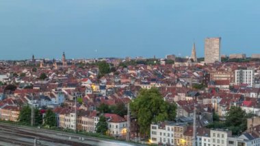 Tren istasyonu yakınlarındaki Schaerbeek 'te Brüksel ufuk çizgisi üzerinde hava gününden geceye geçiş zamanı panoraması. Konut blokları, Saint-Servais Kilisesi ve belediye binası Belçika 'nın kırmızı çatılarıyla çevrili.