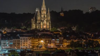 Belçika 'nın başkenti Brüksel' de Notre Dame de Laeken kilisesinin hava manzarası gece saatlerini gösteriyor. Neo-gotik mimari tarihi cephelerle, yemyeşil park alanlarıyla ve aydınlatılmış kentsel manzaralarla çevrili.