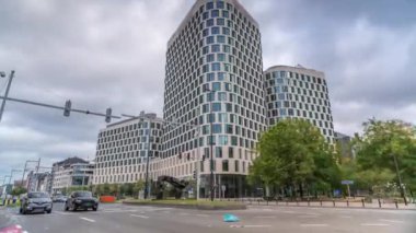 Baudouin Bulvarı, Brüksel, Belçika 'daki iş alanındaki trafik ve modern ofis binalarının zaman çizelgesi. Kavşağın yanındaki çağdaş kuleler bulutlu bir gökyüzünün altına park ederler.