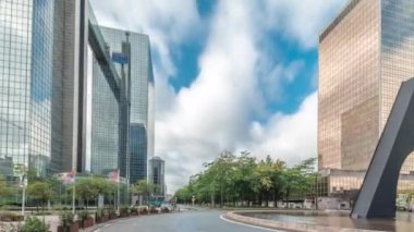 Panorama, Brüksel Kuzey İstasyonu yakınlarındaki bir kavşakta çeşmeyi gösteriyor. Simon Bolivar ve Roi Albert II caddelerinin kesişiminde gökdelenlerle çevrili trafik akıntıları var. Belçika