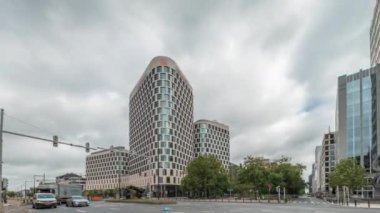 Baudouin Bulvarı, Brüksel, Belçika 'daki iş bölgesi zaman çizelgesinde trafik ve modern ofis binalarını gösteren panorama. Kavşağın yanındaki çağdaş kuleler bulutlu bir gökyüzünün altına park ederler.