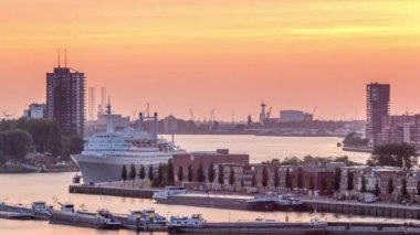 Hollanda 'nın Rotterdam şehrinde gün batımında Maashaven Limanı' nın hava zamanı. Rıhtımın ufuk çizgisi ve eski bir yolcu gemisi olan SS Rotterdam, şimdi Katendrecht 'e demirlemiş bir otel.