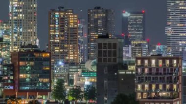 Rotterdam şehir merkezi, Hollanda 'daki modern binaların uçuş zamanı. Finans bölgesinde aydınlık kuleler ve gökdelenler. Parlayan pencereler, parlak bir gece silueti oluşturuyor.