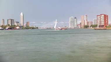 Hollanda, Rotterdam 'daki Maas Nehri' ni kapsayan Kuğu adlı Erasmus Köprüsü zaman çizelgesi panoraması. Hollands 'ın en büyük kablo destekli basküle köprüsü gökdelenleri, tekneleri ve bulutlu mavi gökyüzü