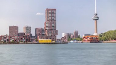 Rotterdam şehri zaman çizelgesi, Euromast gözlem kulesi ve Nieuwe Maas Nehri 'nde bir turist teknesi. Rıhtımda modern gökdelenler, yüzen bir Çin restoranı ve manzaralı bir liman manzarası yer alıyor.