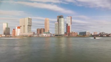 Panorama, Nieuwe Maas River bankasından Wilhelminapier ve Kop van Zuid 'e kadar olan zaman çizelgesini gösteriyor. Modern gökdelenler, gemi terminali ve Erasmus Köprüsü, kıyıdan geçen tekneler.