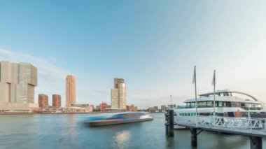 Panorama, Nieuwe Maas River bankasından Wilhelminapier ve Kop van Zuid 'e kadar olan zaman çizelgesini gösteriyor. Modern gökdelenler, feribot istasyonu ve Erasmus Köprüsü, kıyıdan geçen tekneler.
