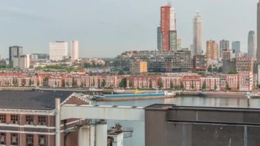 Rotterdam, Hollanda 'daki Katendrecht Yarımadası ve Maashaven Limanı' nın panoramik zaman çizelgesi. Sabah şehir silueti, modern gökdelenler ve Hollanda kıyısı evleri olan eski fabrikalar.