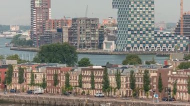 Rotterdam, Hollanda 'daki Katendrecht Yarımadası ve Maashaven Limanı' nın panoramik zaman çizelgesi. Şehir sabahları gökdelenler, vinçler ve geleneksel Hollanda rıhtım evleri.