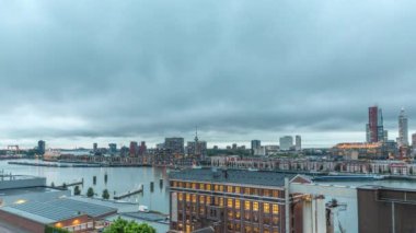 Rotterdam 'daki Katendrecht ve Maas Nehri' nin dramatik gökyüzü, Maashaven 'ın gündüz ve gece arası panoramik görüntüsü. Eski fabrika yakınlarındaki trafik ofis ve etkinlik alanına dönüştü