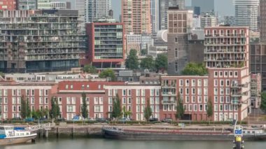 Rotterdam şehir merkezi, Hollanda 'daki modern binaların uçuş zamanı. Finans bölgesindeki kuleler ve gökdelenler sabah sıcacık ışıklarıyla canlı bir ufuk çizgisi oluşturuyor. Rıhtımdaki gemiler