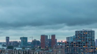 Rotterdam, Hollanda 'daki Katendrecht Yarımadası ve Maashaven Limanı' nın panoramik hava ve gece geçiş zamanı. Şehir silueti modern gökdelenler ve geleneksel Hollanda rıhtım evleri