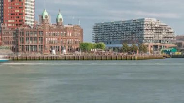 Rotterdam şehir merkezindeki Hotel New York tarihi cepheli modern binaların zaman çizelgesi. Eski Hollanda-Amerika Hat Karargahı. Tekneler geçerken insanlar rıhtımda dinleniyor. Simgesel mimari