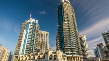 Dubai Marina modern uzun kuleleri, Birleşik Arap Emirlikleri 'ndeki gezinti zamanlarından suya yansıdı. Dubai 'de bir bölge ve yapay bir kanal. Mavi bulutlu gökyüzü