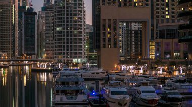 Yatı ve Dubai 'deki köprüden modern kuleleri olan liman kıyısı, geçiş zamanı, Birleşik Arap Emirlikleri. Dubai Marina, Dubai 'de bir şehirdir.